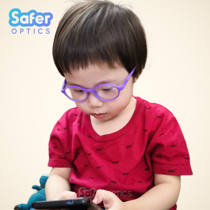 Toddler with SaferOptics glasses focused on mobile phone